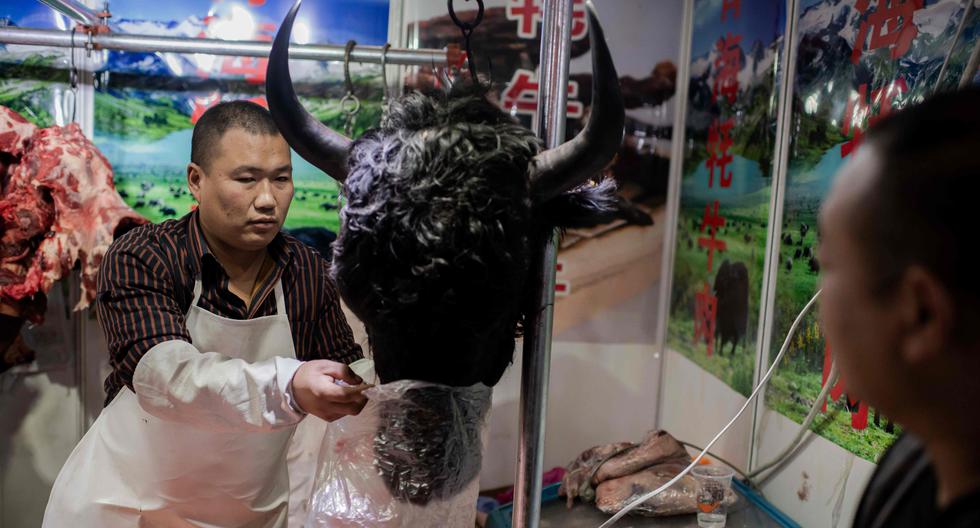 En esta fotografía captada el 15 de enero se ve a un comerciante alistando una cabeza de yak que acaba de ser comprada en un mercado húmedo de Beijing, China. Por esa fecha, la OMS ya apuntaba a que el origen del COVID-19 era animal y las autoridades chinas señalaban al mercado de Huanan, en Wuhan, como el disparador del brote. (Foto: Nicolas Asfouri / AFP)