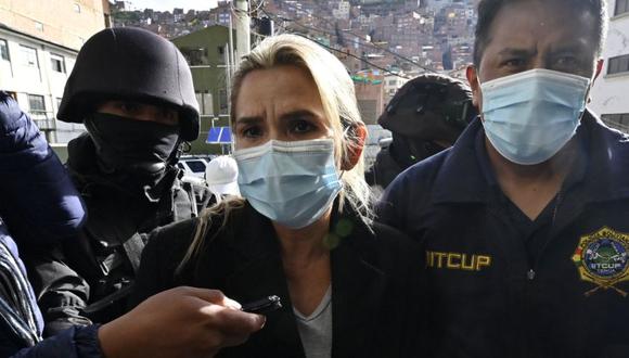 La expresidenta interina de Bolivia, Jeanine Anez (Centro), es escoltada por miembros de la policía de la Fuerza Especial contra el Crimen (FELCC) después de ser arrestada en La Paz. (Foto archivo/ AIZAR RALDES / AFP).