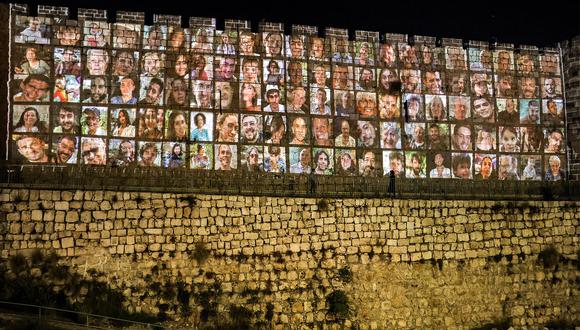 Las murallas de la ciudad vieja de Jerusalén, en las que se proyectan imágenes de los rehenes secuestrados por militantes palestinos en el ataque del 7 de octubre y retenidos en la Franja de Gaza, el 6 de noviembre de 2023. (Foto de AHMAD GHARABLI / AFP)