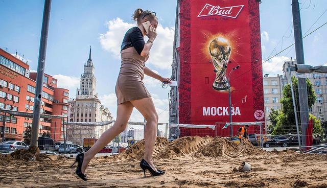 TOPSHOT - A woman with high heels walks on a sidewalk which is renovated on August 10, 2017 in downtown Moscow, as the city continues with preparations for next year's FIFA World Cup.  / AFP / Mladen ANTONOV