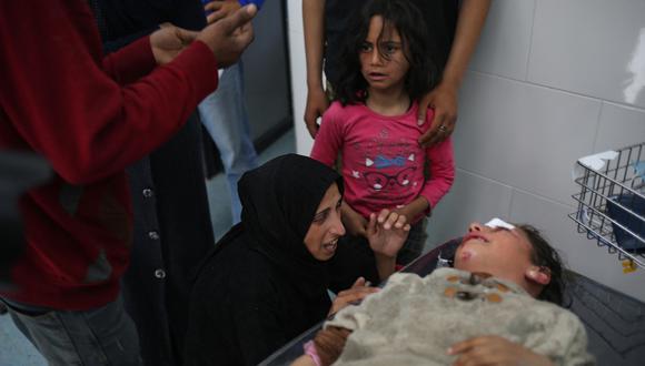 Una mujer consuela a un niño mientras recibe atención médica en el hospital kuwaití por las heridas sufridas en un bombardeo israelí que afectó a un campamento que albergaba a palestinos desplazados cerca del hospital emiratí, en Rafah, en el sur de la Franja de Gaza, el 2 de marzo de 2024, en medio del conflicto en curso entre Israel y el movimiento Hamás. (Foto de AFP)​