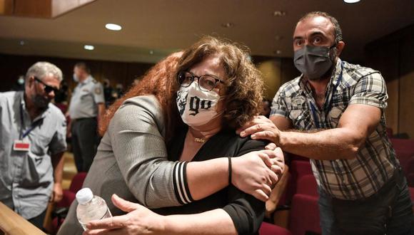 Magda Fyssa, la madre del cantante asesinado Pavlos Fyssas, es abrazada por su hija Irini tras el veredicto contra la agrupación neonazi Amanecer Dorado. (Foto de LOUISA GOULIAMAKI / AFP).