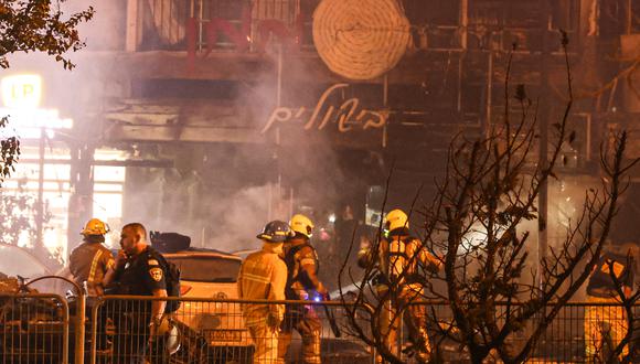 Los bomberos israelíes revisan los escombros de vehículos quemados tras un ataque con cohetes desde el sur del Líbano contra la ciudad de Kiryat Shmona, en el norte de Israel, el 2 de noviembre de 2023. (Foto de Jalaa MAREY / AFP).