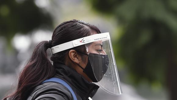Una mujer camina por las calles de México con mascarilla y protector facial. (Foto: ALFREDO ESTRELLA / AFP)