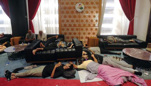 Manifestantes iraquíes descansan dentro del Parlamento, en Bagdad, Irak.