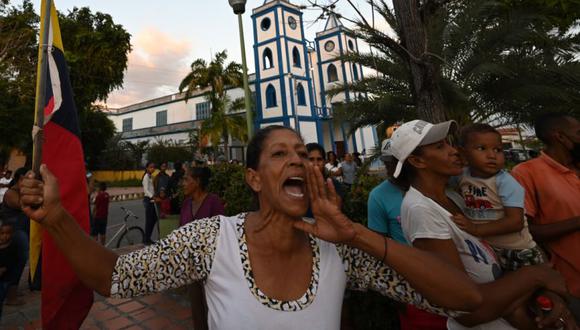 Una mujer grita consignas mientras familiares y amigos de 28 migrantes venezolanos que murieron en el naufragio de un barco que los transportaba a Trinidad y Tobago, protestan en la plaza principal de Guiria, Venezuela. (Foto: AFP / YURI CORTEZ).