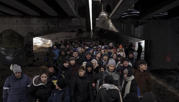 Gente reunida bajo un puente destruido mientras trata de huir cruzando el río Irpín, a las afueras de Kiev, Ucrania, el martes 8 de marzo de 2022. (Foto de archivo: AP/Felipe Dana)