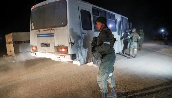 Un autobús que transporta a miembros del servicio de las fuerzas ucranianas de la acería sitiada Azovstal se aleja escoltado por el ejército prorruso. (REUTERS/Alexander Ermochenko)
