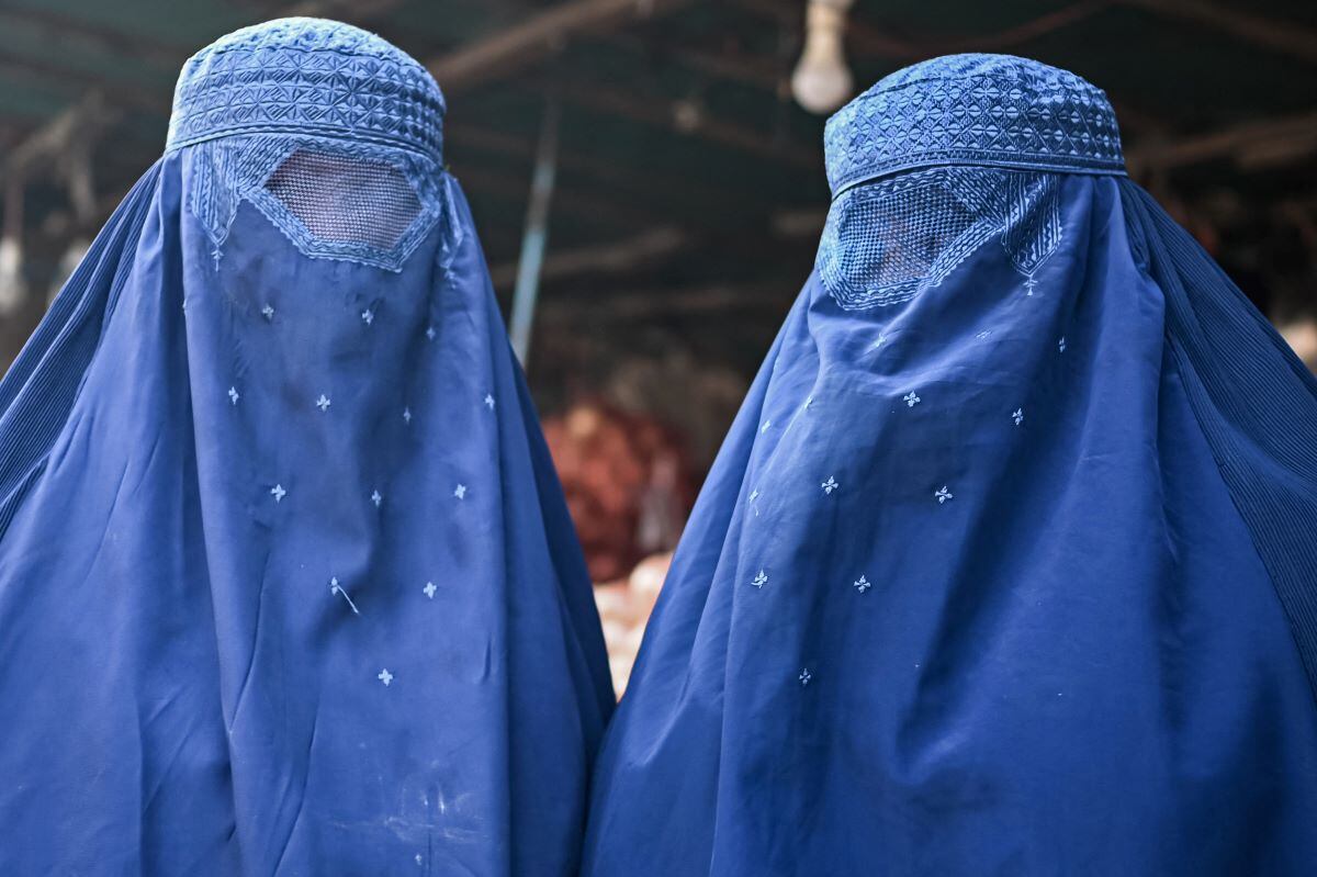 Burqa-clad Afghan women at a market in Kabul, the capital of Afghanistan, on December 20, 2021. (Mohd RASFAN / AFP).