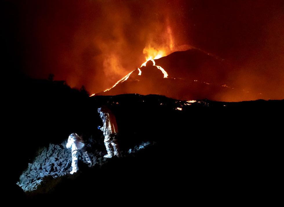Esta foto de la Unidad Militar de Emergencias (UME) de España del 16 de octubre de 2021 muestra a miembros del Grupo de Intervención en Emergencias Tecnológicas y Ambientales monitoreando la evolución de un nuevo flujo de lava tras la erupción de el volcán de La Palma. (LUISMI ORTIZ / UME / AFP).