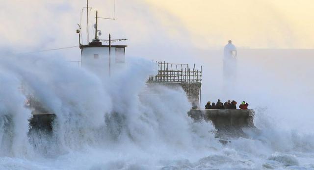 Las olas chocan contra el malecón y el faro de Porthcawl en Porthcawl, Bridgend, Gales, Gran Bretaña, cuando la tormenta Eunice toca tierra el viernes 18 de febrero. (Jacob King/PA vía AP)