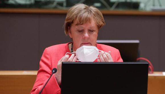 La canciller alemana Angela Merkel se pone una mascarilla facial durante una última mesa redonda después de la cumbre de la Unión Europea celebrada en Bruselas. (EFE / EPA / STEPHANIE LECOCQ / POOL).