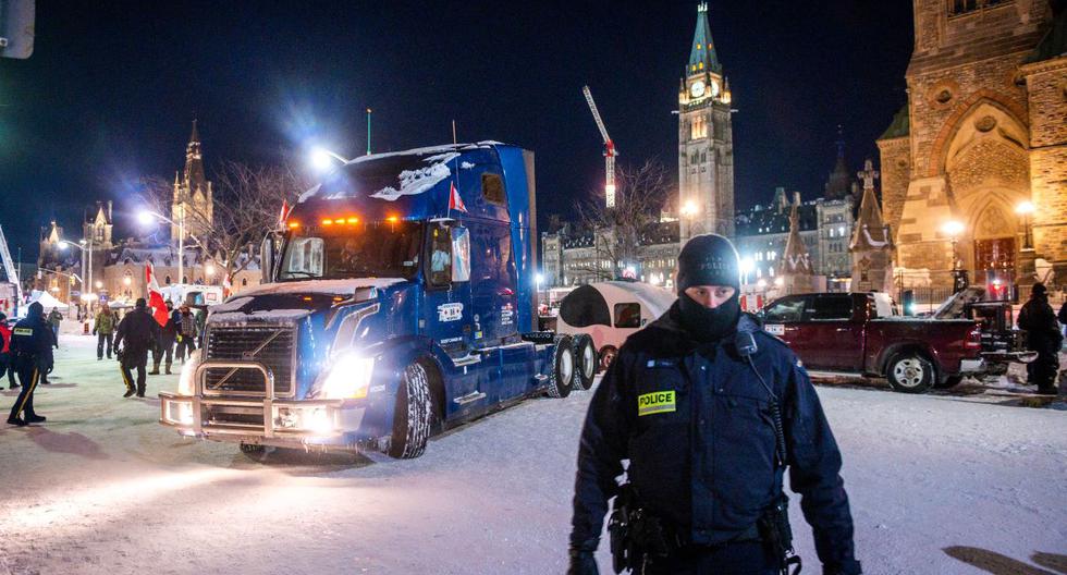 Un oficial de policía espera mientras un camión sale de Parliament Hill durante una protesta encabezada por camioneros contra las restricciones por coronavirus en Ottawa, Canadá. (ANDREJ IVANOV / AFP).