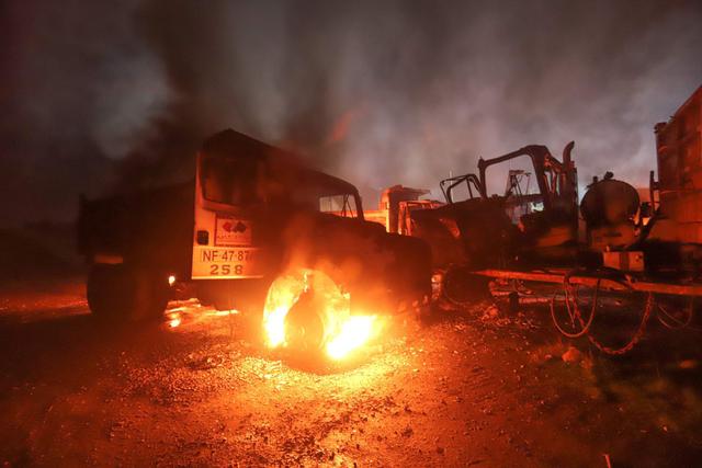 Vista de un camión y una máquina que fueron incendiadas por atacantes desconocidos cerca de Temuco, región de La Araucanía, Chile. (AFP / MARIO QUILODRÁN).