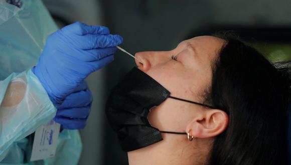 Una trabajadora de la salud toma una muestra nasal de una mujer para una prueba de PCR de coronavirus COVID-19 en Santiago de Chile, el 26 de enero de 2022. (JAVIER TORRES / AFP).