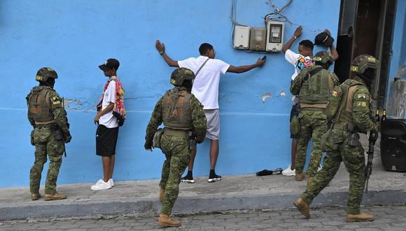Miembros de las Fuerzas de Élite del Ejército cachean a hombres y verifican sus identidades durante un patrullaje en las calles de Morán, un barrio del norte de Quito, el 11 de enero de 2024. (Foto de AFP)