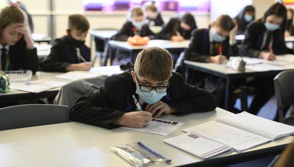 Year 8 students wear face masks or coverings to mitigate the spread of Covid-19, as they take part in an English class at Park Lane Academy in Halifax, northwest England on January 4, 2022. (Photo by OLI SCARFF / AFP)