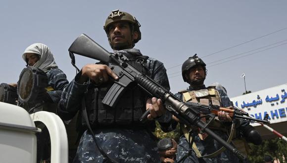 Combatientes talibanes escoltan a mujeres con velo que marchaban durante una manifestación a favor de los talibanes frente a la Universidad de Educación Shaheed Rabbani en Kabul el 11 de septiembre de 2021. (Foto: Aamir QURESHI / AFP).