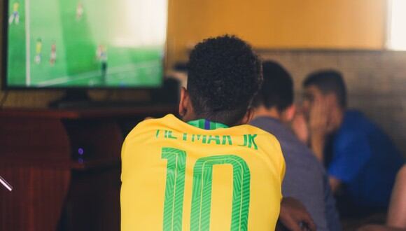 Un hombre mirando un partido en un local. | Imagen referencial: Gustavo Ferreira / Unspash