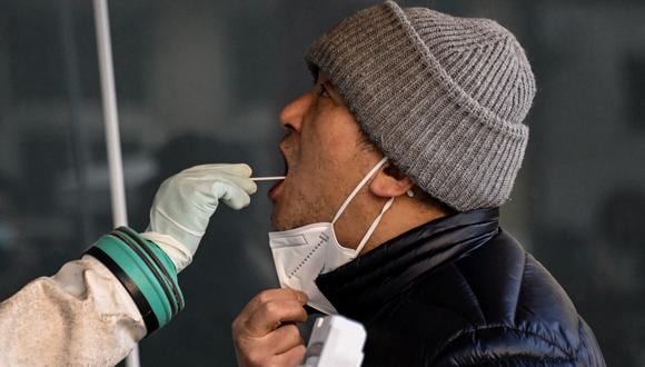 Un trabajador de la salud toma una muestra de hisopo de un hombre para realizarle la prueba del coronavirus COVID-19 en un hospital de Beijing el 26 de diciembre de 2022. (Foto de Noel CELIS / AFP)