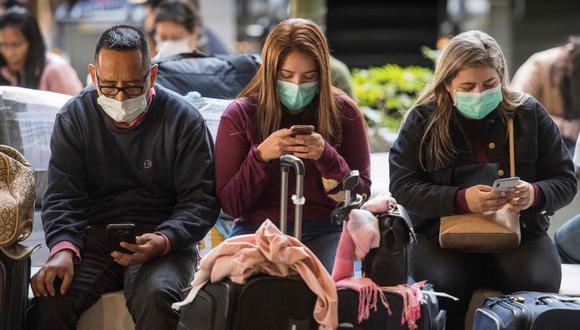 Unos pasajeros usan mascarillas para protegerse contra la propagación del Coronavirus cuando llegan en un vuelo desde Asia al Aeropuerto Internacional de Los Ángeles, California. (Foto: Archivo/AFP).