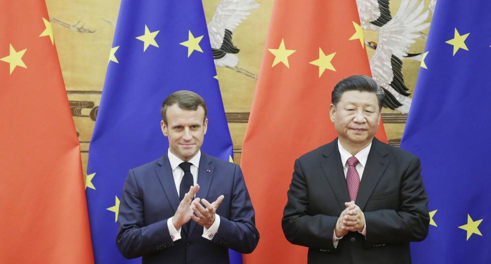 El presidente de China, Xi Jinping, y el presidente de Francia, Emmanuel Macron, se paran frente a las banderas de China y la UE en una ceremonia de firma en el Gran Salón del Pueblo en Beijing. (AFP)