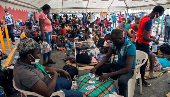 Los migrantes haitianos juegan a las cartas y descansan afuera de un refugio en Monterrey, México, el 26 de septiembre de 2021. (Julio Cesar AGUILAR / AFP).
