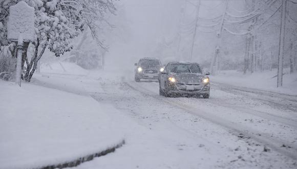 Los viajeros conducen sobre la nieve en Norwood, Nueva Jersey, el 13 de febrero de 2024. (Foto de Kena Betancur / AFP)