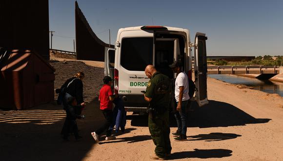 Un agente de la Patrulla Fronteriza carga a una familia migrante que busca asilo en una camioneta cuando se presentan después de cruzar a los EE. UU. desde México. (Patrick T. FALLON / AFP) (Photo by Patrick T. FALLON / AFP)