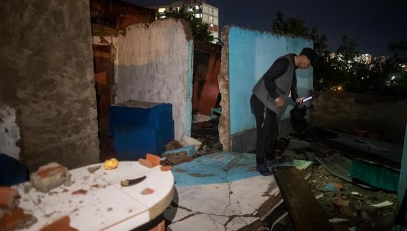Un hombre toma fotos con su teléfono en una casa derrumbada en Caracas, Venezuela, tras las intensas lluvias del 24 de octubre del 2022. (EFE/ Miguel Gutiérrez).
