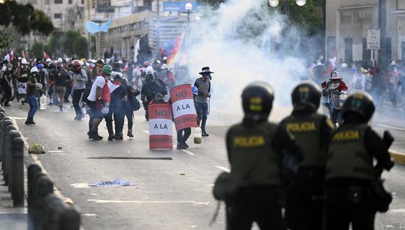 Policías antidisturbios chocan con manifestantes durante una protesta contra el gobierno de Dina Boluarte que pide su renuncia y el cierre del Congreso, en Lima el 24 de enero de 2023. (Foto por Ernesto Benavides / AFP)