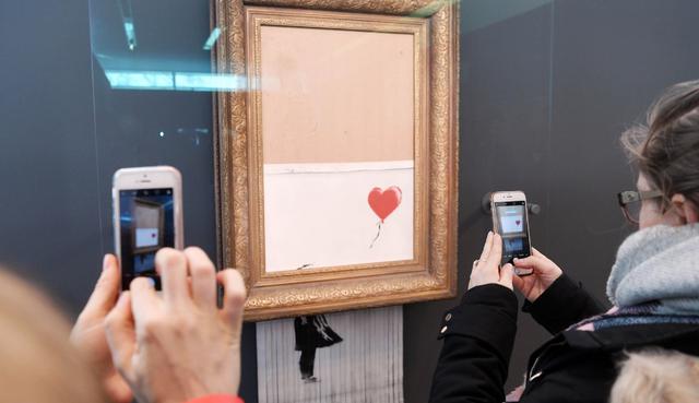 El artista callejero causó sensación en octubre cuando hizo que una obra suya quedara parcialmente rasgada instantes después de haberse vendido en una millonaria subasta. (Fotos: AFP)