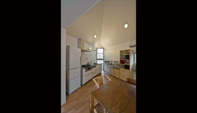 La cocina se encuentra en uno de los vértices de la casa. Esta destaca por el uso de muebles de madera, los cuales se amoldan bien a la forma del espacio. (Foto: Mizuishi Architects/ Hiroshi Tanigawa)