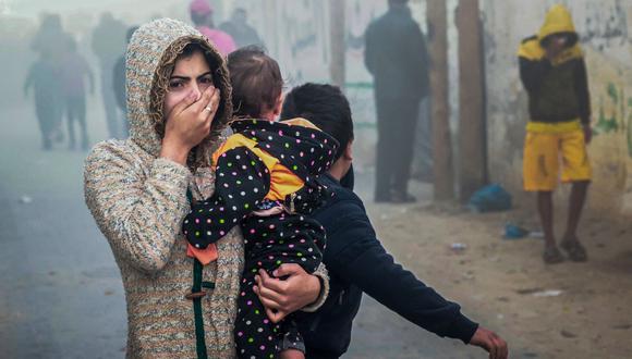 Una mujer que sostiene a un niño huye tras un ataque israelí en Rafah, en el sur de la Franja de Gaza, el 23 de noviembre de 2023, en medio de batallas en curso entre Israel y el grupo militante palestino Hamás. (Foto de Mohammed ABED / AFP)