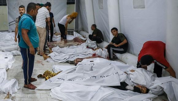 Personas cargan cadáveres de palestinos muertos en un ataque al hospital Ahli Arab en el centro de Gaza después de ser transportados al hospital Al-Shifa, el 17 de octubre de 2023. (Foto de Dawood NEMER / AFP)