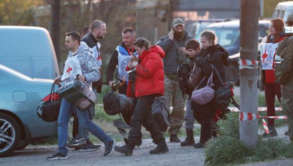 Los civiles evacuados de la planta siderúrgica de Azovstal en Mariupol caminan acompañados por miembros del Comité Internacional de la Cruz Roja (CICR) .