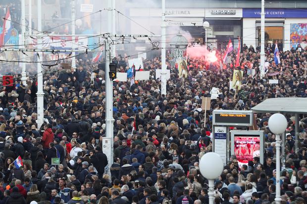 El humo se eleva de una bengala encendida mientras los manifestantes se reúnen para protestar contra las medidas de la enfermedad del coronavirus (COVID-19), en Zagreb, Croacia, el 20 de noviembre de 2021. (REUTERS / Antonio Bronic).