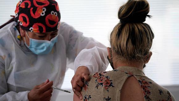 Una migrante venezolana es inoculada contra el coronavirus con la vacuna Johnson & Johnson's en el Centro Distrital de Integración y Derechos de Migrantes, Refugiados y Retornados en Bogotá, el 11 de octubre de 2021. (Raúl ARBOLEDA / AFP).