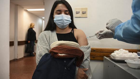 A woman receives a dose of the Pfizer-BioNtech COVID-19 vaccine on August 16, 2021 in Montevideo, as Uruguay launches its campaign to give booster shots to people fully vaccinated with the CoronaVac vaccine, developed by China's Sinovac firm. - With the COVID-19 pandemic virtually controlled, Uruguay begins this Monday to apply a booster dose of the Pfizer vaccine to those inoculated with Coronavac, in a combination on which there are no studies but that local experts consider safe and necessary in the face of the threat of the delta variant. (Photo by Eitan ABRAMOVICH / AFP)