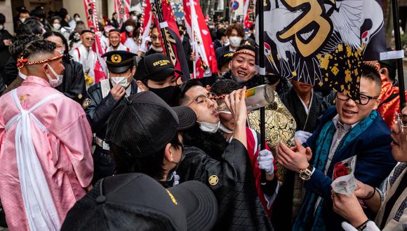 Un joven (C) celebra con una bebida para conmemorar el "Día de la mayoría de edad", cuando Japón honra a las personas que cumplen 20 años este año para significar la edad adulta, en una calle de Yokohama el 10 de enero de 2022. Foto de archivo.