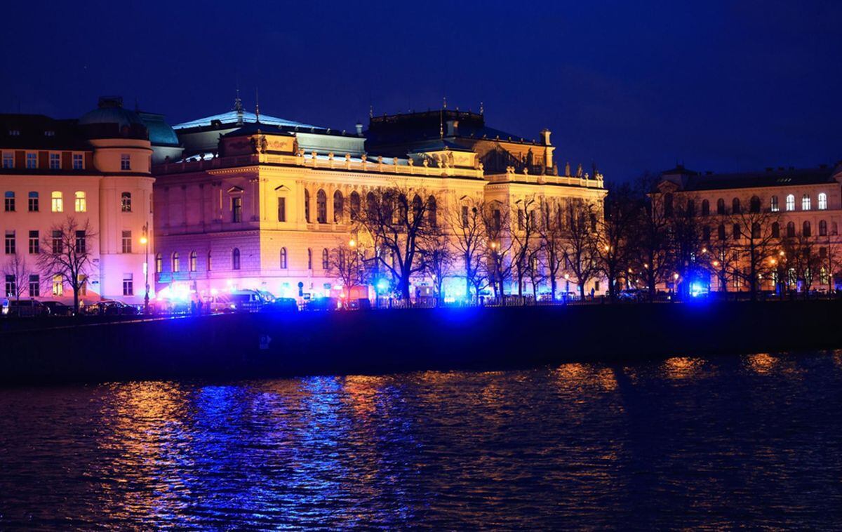 The lights of emergency service vehicles illuminate the scene of a shooting at Charles University in central Prague on December 21, 2023. According to Czech police, several people were killed and 