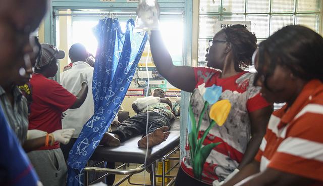 Nurses and doctors work to stabilise Victor Odhiambo (in the background), 22, who sustained a gunshot wound to the forearm on October 26, 2017 in Kisumu.  Kenyans trickled into polling stations on October 26 for a repeat election that has polarised the nation, amid sporadic clashes as supporters of opposition leader ignored his call to stay away and tried to block voting. / AFP / Jennifer Huxta
