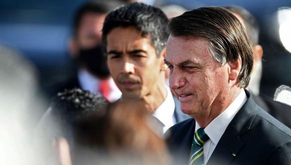 El presidente de Brasil, Jair Bolsonaro, habla con simpatizantes durante la ceremonia de izamiento de la bandera nacional antes de una reunión ministerial en el Palacio de la Alvorada, el 27 de octubre de 2020 (Foto de EVARISTO SA / AFP).