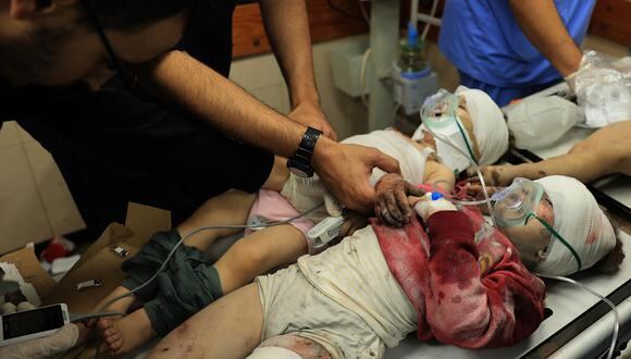 Dos niños palestinos heridos son examinados mientras yacen en una camilla en el Hospital Al-Aqsa tras el bombardeo israelí en Deir el-Balah, en el centro de la Franja de Gaza, el 15 de noviembre de 2023, en medio del actual Batallas entre Israel y el grupo palestino Hamás. (Foto de Bashar TALEB / AFP)