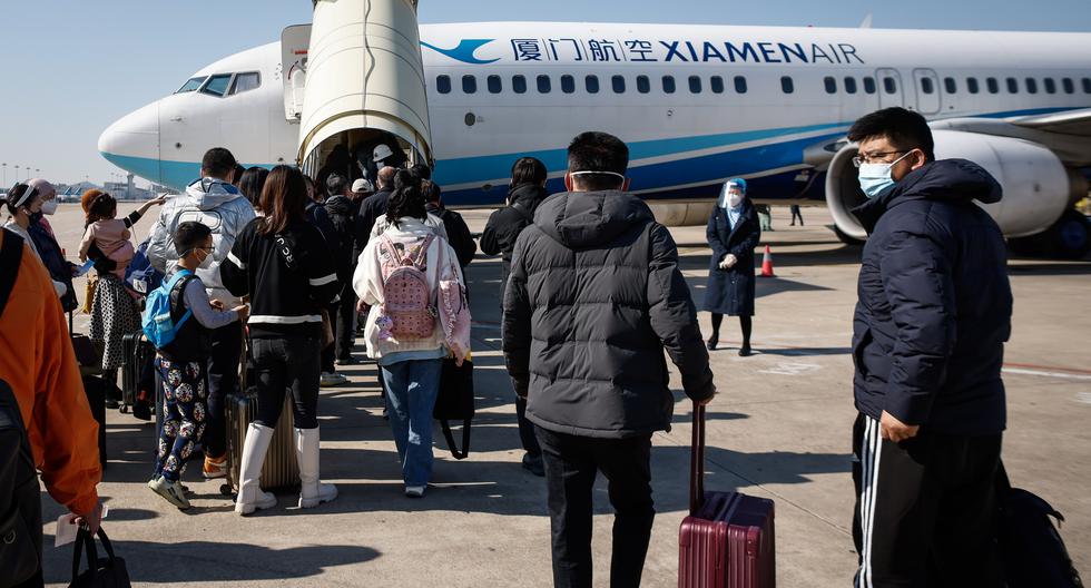 Tras el levantamiento de restricciones, muchos chinos están regresando a trabajar a ciudades como Beijing o Shanghái. Estos ciudadanos toman un avión en el Aeropuerto Internacional Xiamen Gaoqi en Xiamen, provincia de Fujian. EFE/EPA/MARK R. CRISTINO