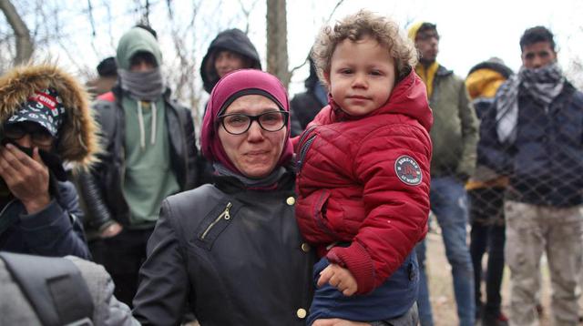 Una madre refugiada con su hijo se encuentran en el lado turco de la frontera cerrada entre Turquía y Grecia, Edirne, Turquía. (Foto: AFP).