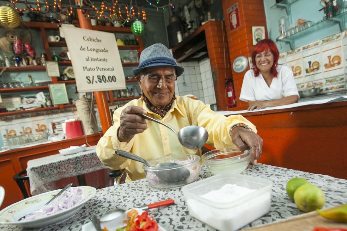 Don Pedro Solari listo para preparar su cebiche, ante la mirada de Teresa Morán, su sobrina, que lo acompañó y lo cuidó hasta el último día. (Foto: Víctor Idrogo/Archivo El Comercio)