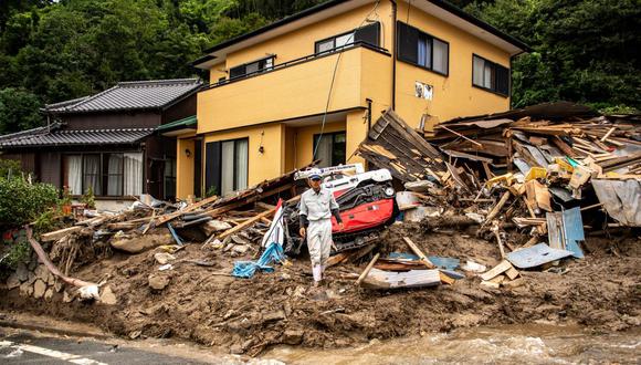 Un empleado de una empresa de construcción trabaja entre escombros frente a una casa en Kanzaki, prefectura de Saga, Japón, el 15 de agosto de 2021.
(Philip FONG / AFP).