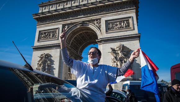 Los participantes en el llamado "Convoy de la libertad" ondean banderas mientras intentan bloquear el tráfico en los Campos Elíseos en París, Francia, el 12 de febrero de 2022. (EFE/EPA/CHRISTOPHE PETIT TESSON).