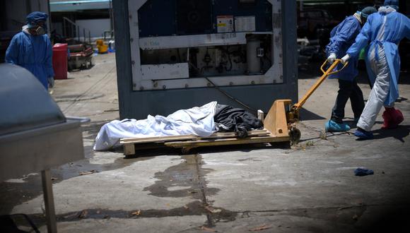 Trabajadores de la salud que usan equipo de protección llevan un cadáver a un contenedor refrigerado fuera del Hospital Teodoro Maldonado Carbo en Guayaquil, Ecuador. (REUTERS / Vicente Gaibor del Pino).
